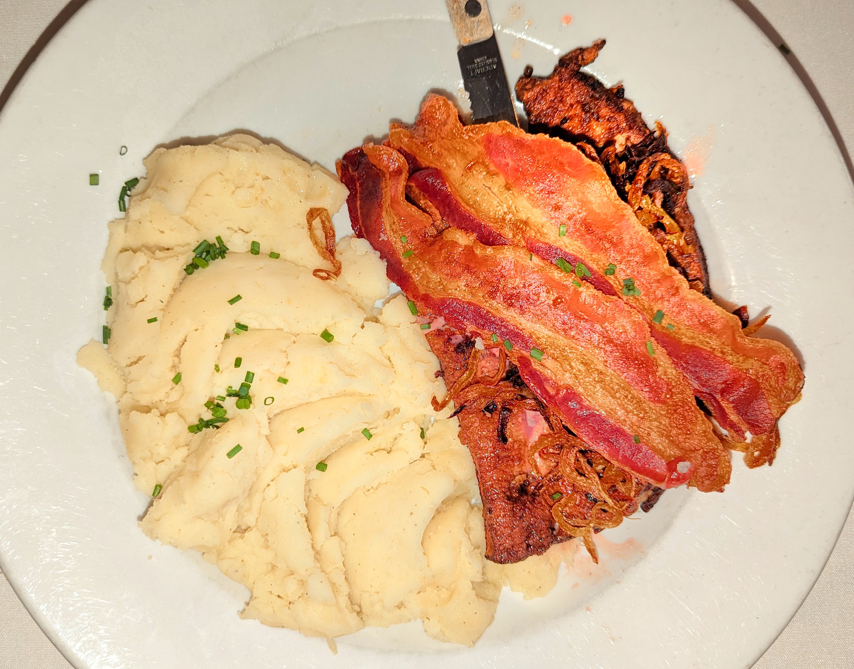 Plate of liver with caramelized onions, bacon, and mashed potatoes